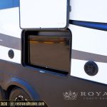 Exterior entertainment window with flat-screen TV on white and blue RV with two round speakers