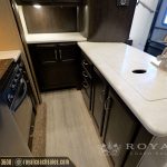 RV kitchen with stainless steel appliances, white countertops, dark cabinetry, and gas stovetop