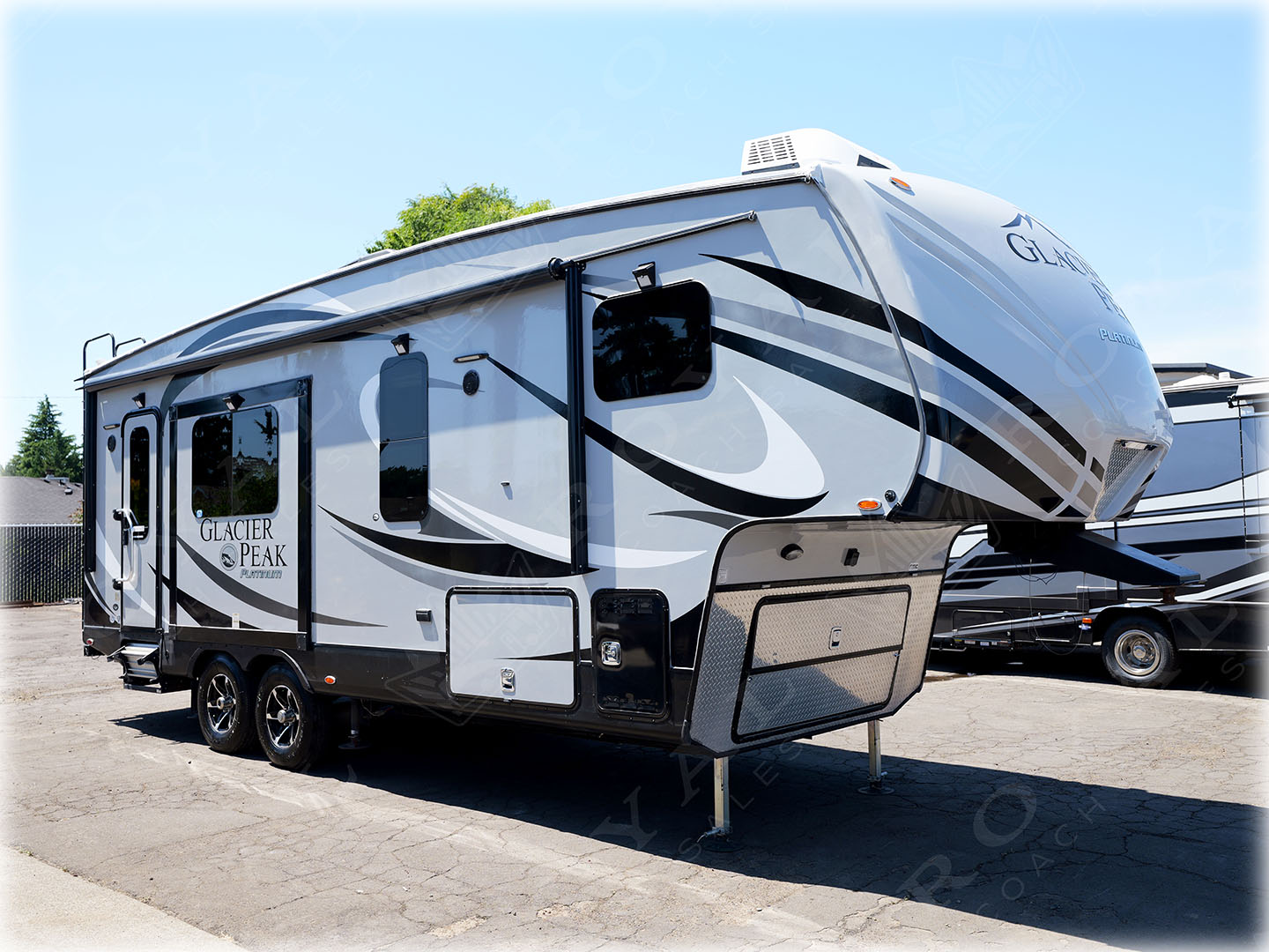 Exterior view of Glacier Peak RV travel trailer with white and black exterior and extended awning