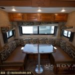 RV living area with booth seating, patterned cushions, wooden cabinetry, windows with shades, and dinette table labeled Glacier Peak