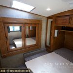 Master bedroom in RV with mirrored wardrobe cabinet, wood cabinetry, skylights, and carpet flooring