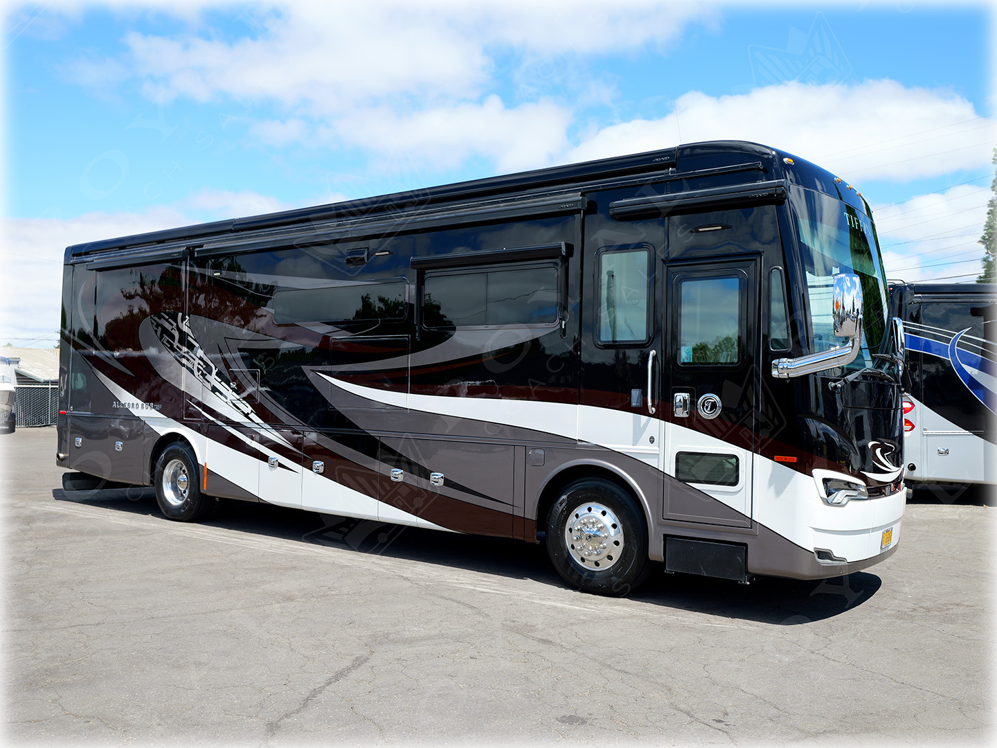 Luxury motorhome with burgundy and white exterior paint scheme parked in lot