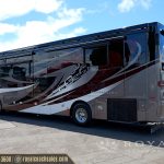 Rear three-quarter view of burgundy and white Allegro motorcoach class A RV with extended slide-outs