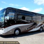 Side profile of brown and white Griffin motorcoach RV with tinted windows parked outdoors