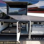 RV exterior slide-out storage compartments with Dometic refrigerator unit and open cabinet doors on motorcoach