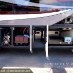 RV exterior compartments open showing diesel engine, batteries, water system and storage areas