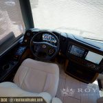 Motorcoach interior cockpit view showing steering wheel, digital gauges, and climate control systems