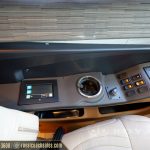 Luxury motorcoach dashboard control panel with touchscreen display, cup holder, and multiple button controls